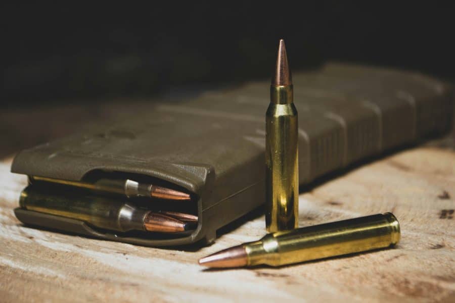 2A Marketplace: Private Firearm Classifieds A close-up of three rifle bullets, with two standing upright and one lying down, next to a loaded ammunition magazine on a wooden surface. Private sale of guns. 2A Marketplace: Private Firearm Classifieds A close-up of three rifle bullets, with two standing upright and one lying down, next to a loaded ammunition magazine on a wooden surface. Private sale of guns.