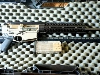 2A Marketplace: Private Firearm Classifieds A semi-automatic rifle with a black and silver finish is placed in a foam-lined hard case, with a transparent magazine positioned below the rifle. Private sale of guns.