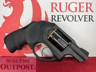 2A Marketplace: Private Firearm Classifieds A black Ruger revolver with a yellow safety device is displayed on a red textured surface in front of a Ruger Revolver box, with SURE FIRE OUTPOST partially visible in the lower left corner. Private sale of guns.